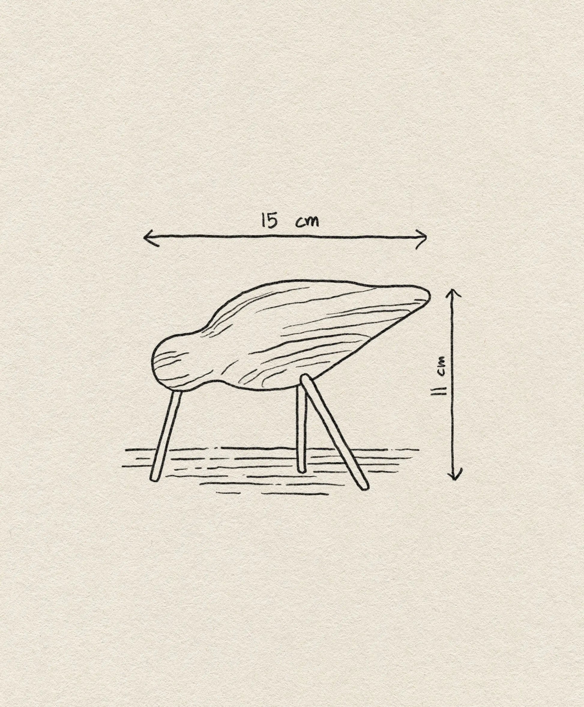 A minimalist line drawing of the Normann Copenhagen Shorebird Medium Oak by Normann Copenhagen, a wooden three-legged object measuring 15 cm wide and 11 cm tall, with arrows indicating its dimensions.