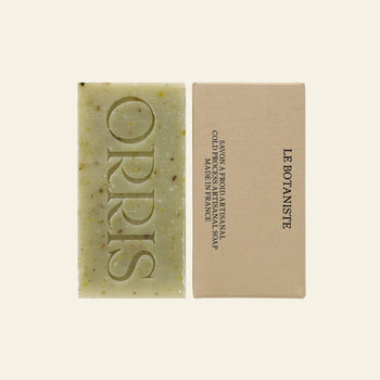 ORRIS Le Botaniste is a natural, handcrafted botanical soap by ORRIS. Made in France, it features visible calendula and botanicals, and comes with beige LE BOTANISTE packaging. ORRIS is engraved on the artisanal bar.
