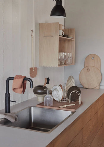A minimalist kitchen with wooden cabinets, black faucet, dish rack, cutting boards, and open shelves is softened by OYOY Living Design Niji Dish Cloths (Pack of 2) in organic cotton—adding comfort to the modern decors neutral palette.