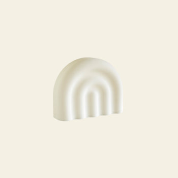 The OYOY Living Design Rainbow Night Light features a white, semi-circular silicone design with an arch-like rainbow pattern, bringing a soothing glow to any room.