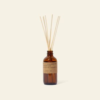 A P.F. Candle Co. 3.5oz Reed Diffuser in Sandalwood Rose stands upright with natural reed sticks on a light background, inviting you to enjoy its signature aromatic scent.