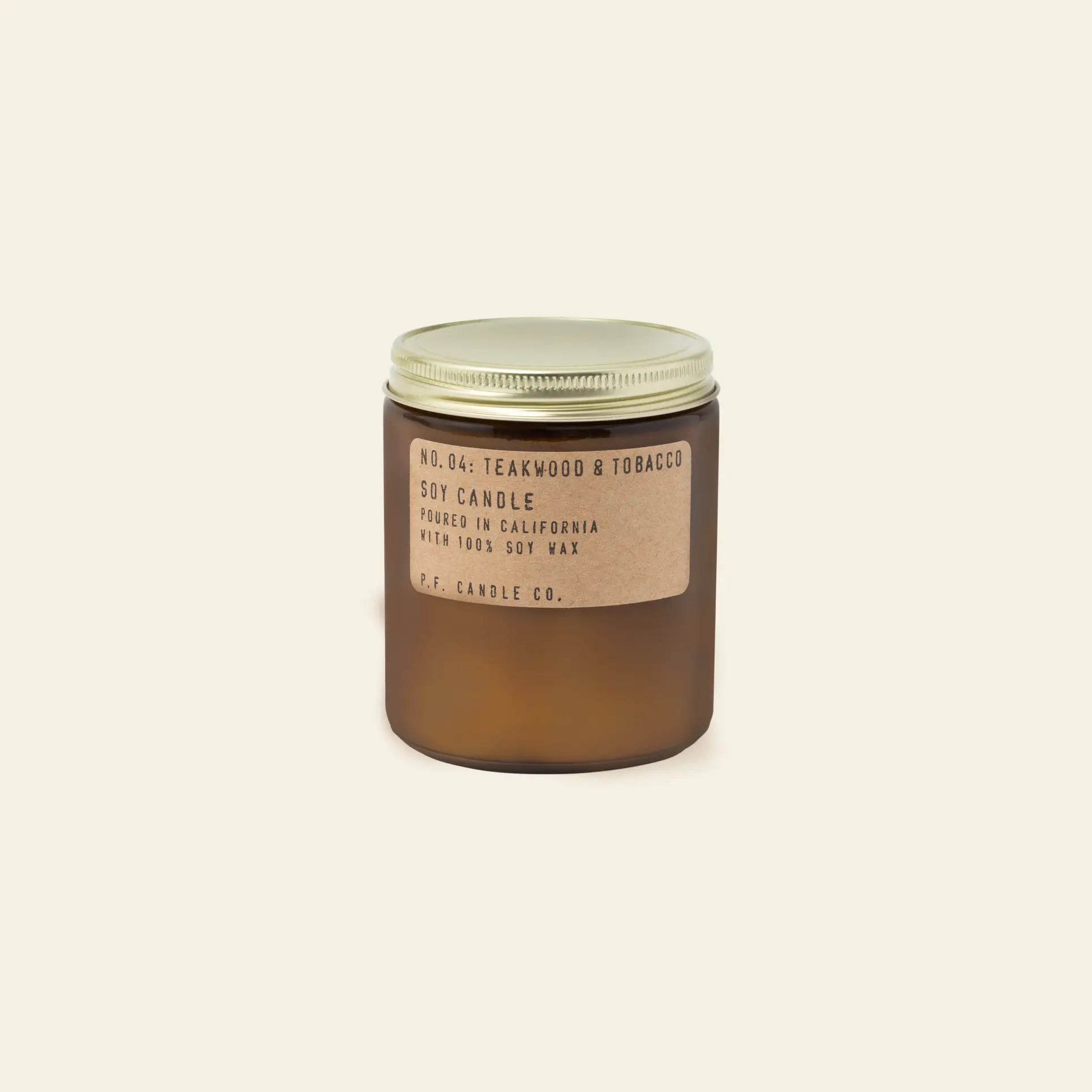 A P.F. Candle Co. No. 4 Teakwood & Tobacco 7.2 oz Soy Candle in a brown glass jar with gold lid and brown label sits on a plain, light background, known for its signature boyfriend scent.