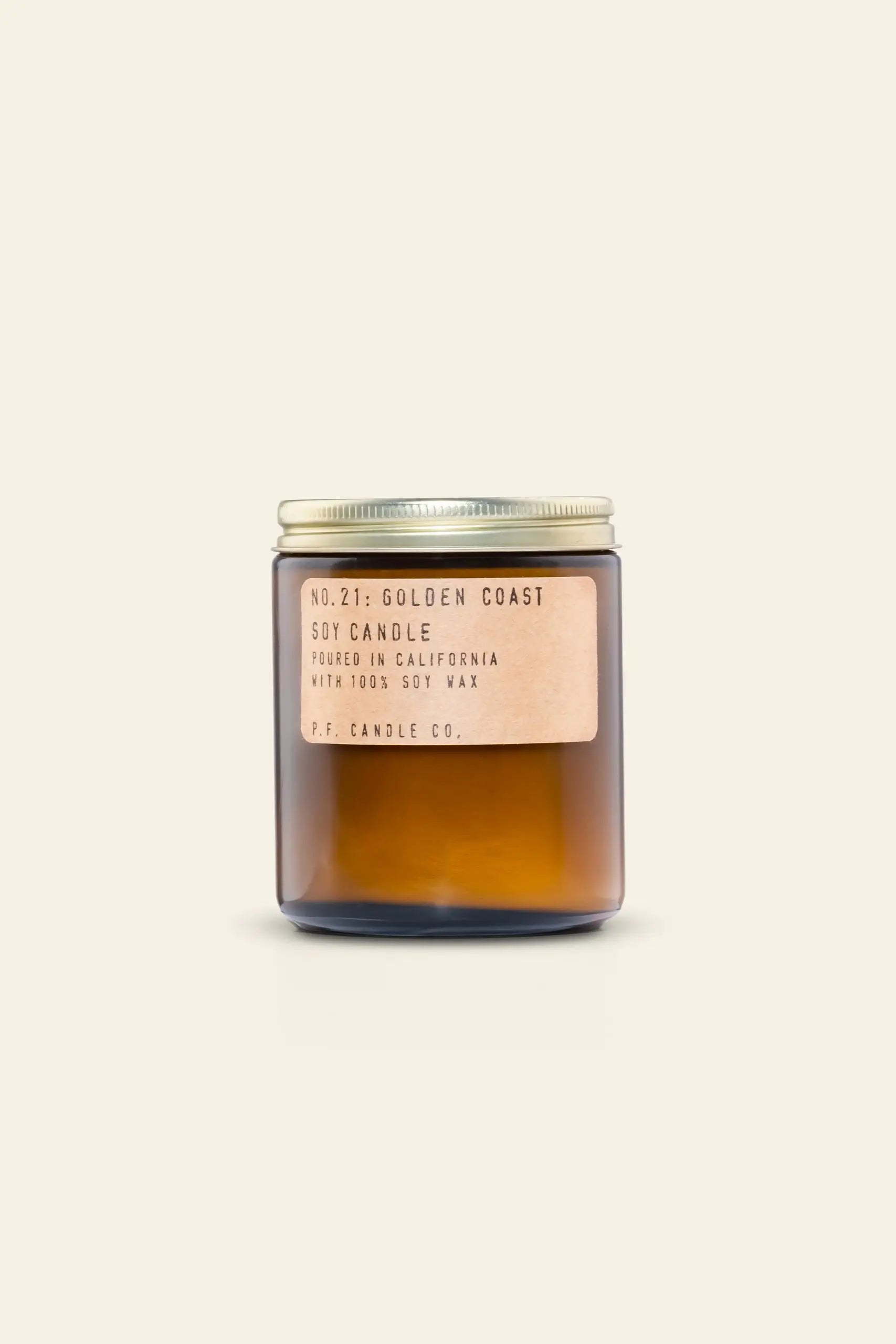 The P.F. Candle Co. No. 21 Golden Coast Soy Candle is a 7.2 oz brown glass jar with a metal lid, featuring eucalyptus notes for fresh coastal vibes. Hand-poured in California with 100% soy wax by P.F. Candle Co., set against a light beige background.