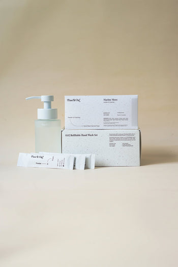 Pass It On 0.02 Refillable Hand Wash Set, Pack of 3-Marine Moss by Pass It On includes a frosted pump bottle, refill packets, and product box—all on a neutral beige background—featuring the fresh scent of Marine Moss.