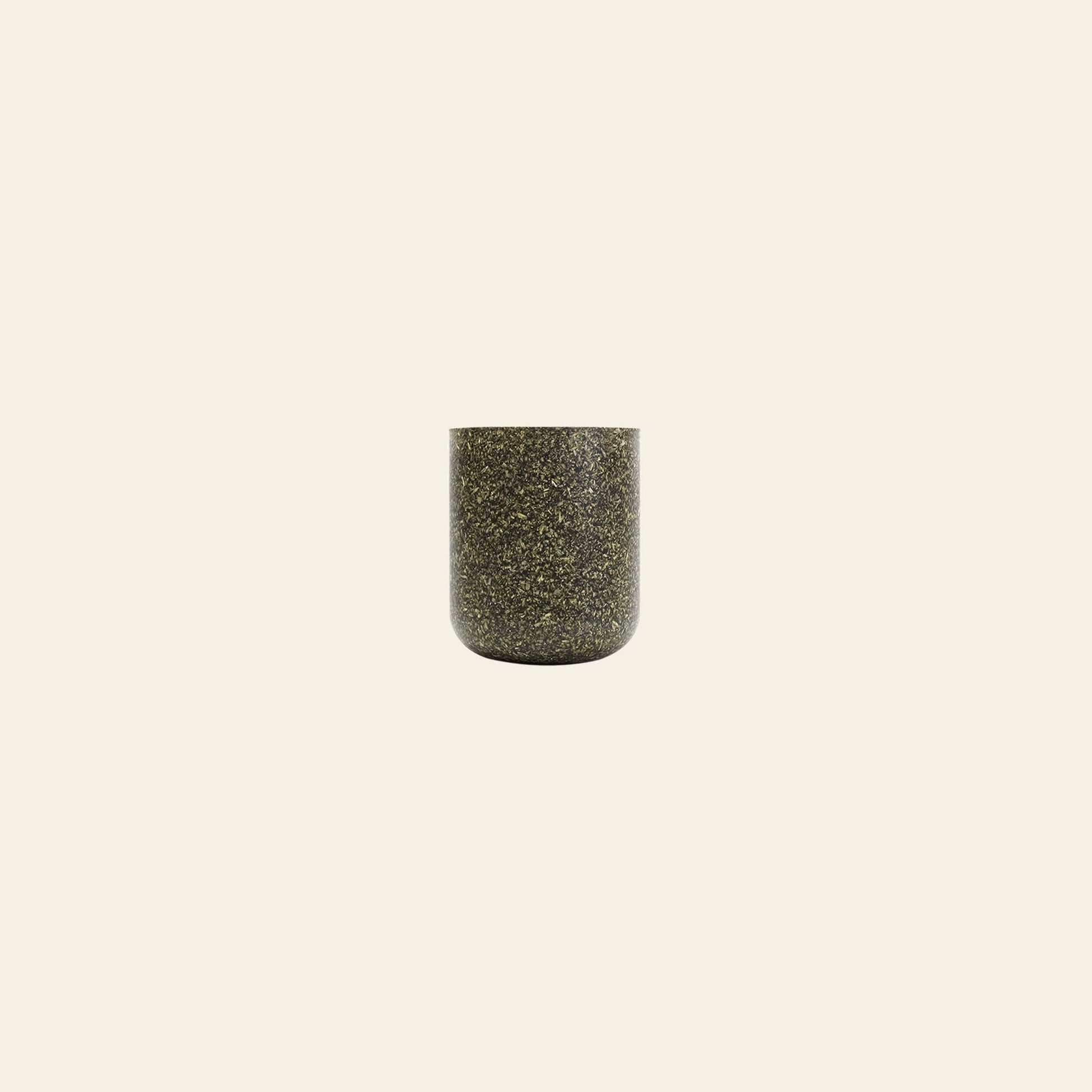 The Pass It On Capsule Cup, Rice Husk—a small, cylindrical cup made from upcycled rice husks with dark speckles—is centered on a plain, light beige background.
