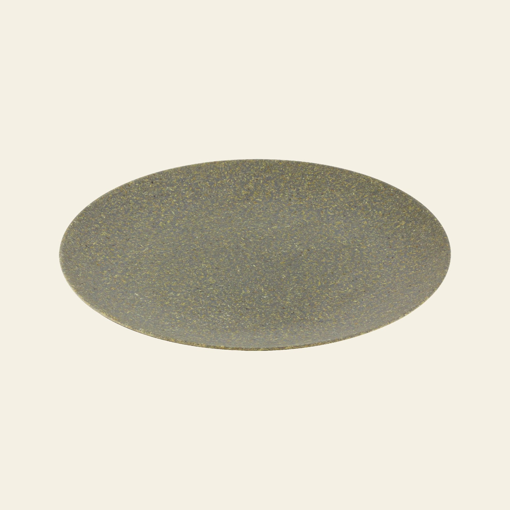 The Pass It On Dining Plate L, Rice Husk by Pass It On features a round, flat, greyish-brown design with a speckled texture—made from upcycled materials and set against an off-white background—ideal for sustainable dining.
