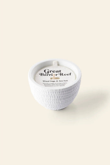 The Pass It On Great Barrier Reef Candle by Pass It On features a white textured ceramic design with a lid, delivering an aromatherapy experience and soothing mineral salt scent.