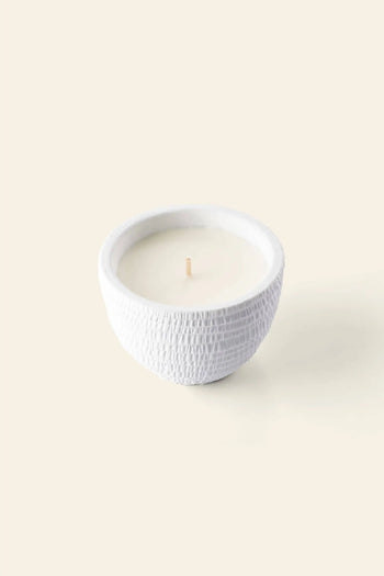 The Pass It On Great Barrier Reef Candle by Pass It On is a white, textured ceramic bowl candle with a single wick and creamy white wax, featuring a soothing mineral salt scent against a light beige background.