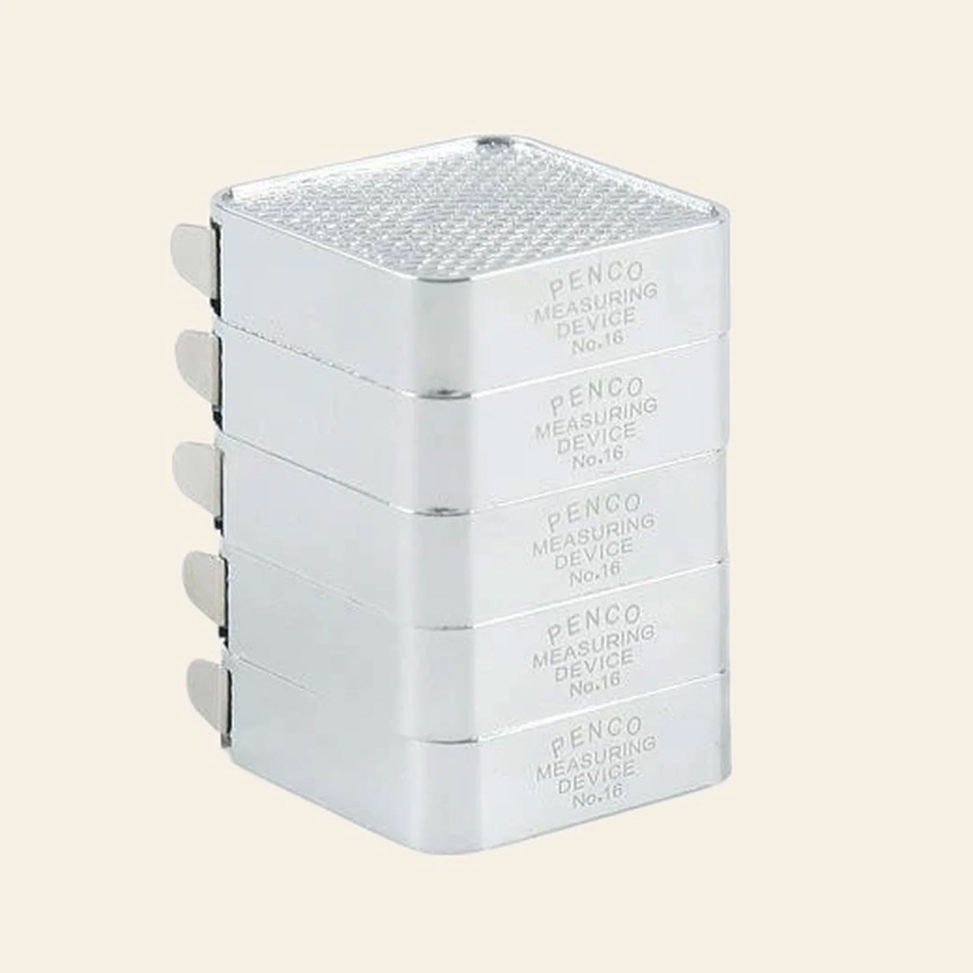 A stack of four silver rectangular metal objects labeled Penco Pocket Measure by Penco, showcasing a retro-inspired design with a textured top and small side tabs, reminiscent of a compact stainless steel measuring tape.