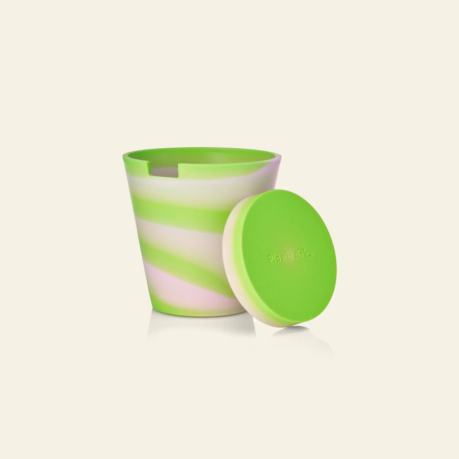The Plastic Ark Dirty Pot by Plastic Ark features a green, white, and light pink marbled silicone cup with a matching solid green lid, reminiscent of recycled plant pots—ideal for sustainable gardening. Displayed on a light beige background.