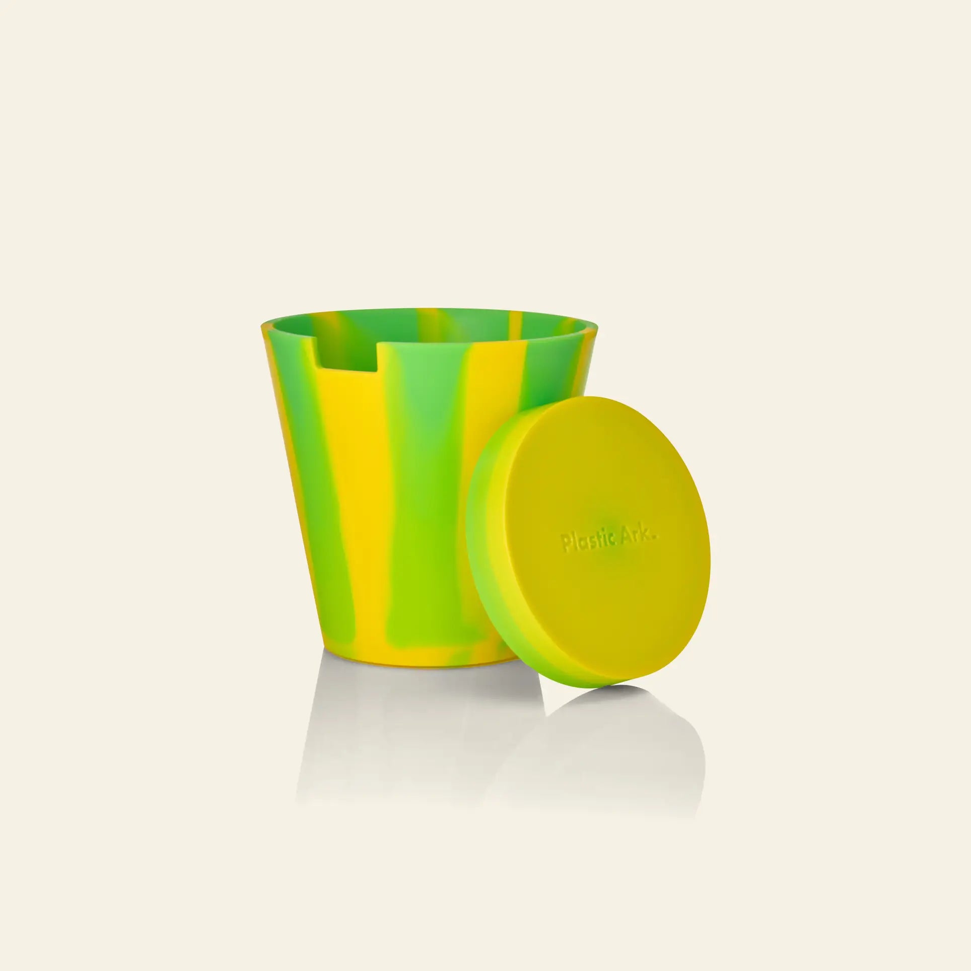 The Plastic Ark Dirty Pot by Plastic Ark features a yellow and green marbled design with a matching round lid on a beige backdrop—ideal as a unique garden pot or sustainable planter for your favorite greenery.