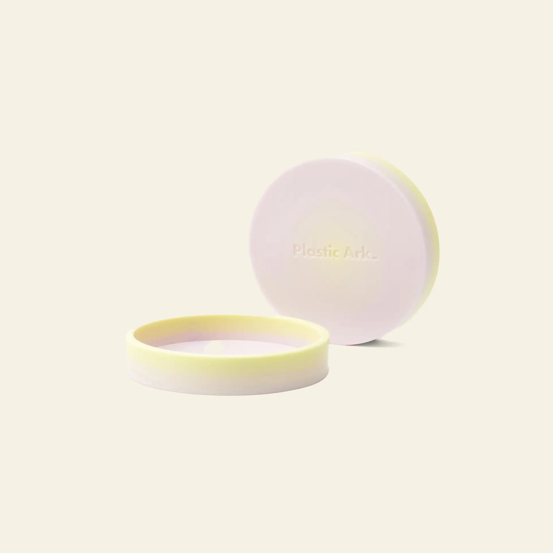Two round, pale yellow and white Plastic Ark Dirty Pot containers—one open, one closed—feature Plastic Ark. embossed on the lid, made from recycled plastic and displayed against an off-white background.