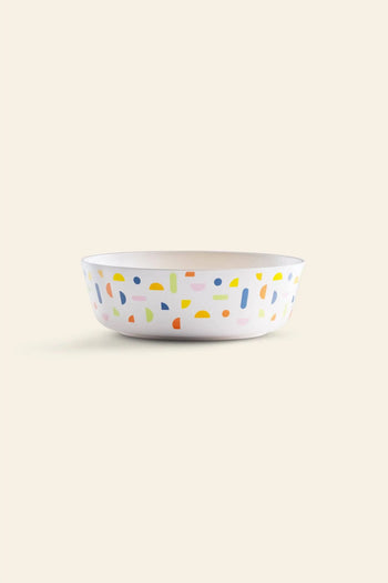 The Poketo Bamboo Bowl by Poketo features playful abstract shapes in yellow, blue, green, pink, and orange on a beige background—a sustainable choice for adding fun to outdoor adventures.