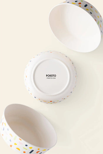 Three Poketo Bamboo Bowls in white ceramic with colorful terrazzo patterns are shown—two displaying their interiors and one upside down to reveal the Poketo brand name. Ideal for outdoor adventures, picnics, or pairing with any bamboo bowl set.
