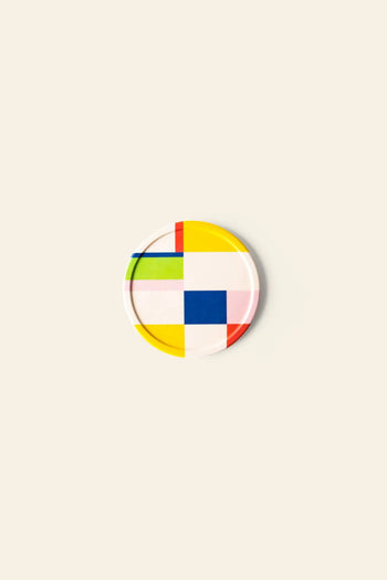 Poketos Bamboo Coasters, Set of 4, feature a geometric design with red, yellow, blue, green, pink, and white blocks on a light beige background. Crafted from durable bamboo fibres.