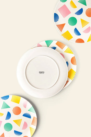 Set of four Poketo Bamboo Dinner Plates featuring vibrant geometric patterns in blue, yellow, pink, orange, and green; one plate is flipped to display a plain white back with the Poketo logo—ideal for eco-friendly gatherings.