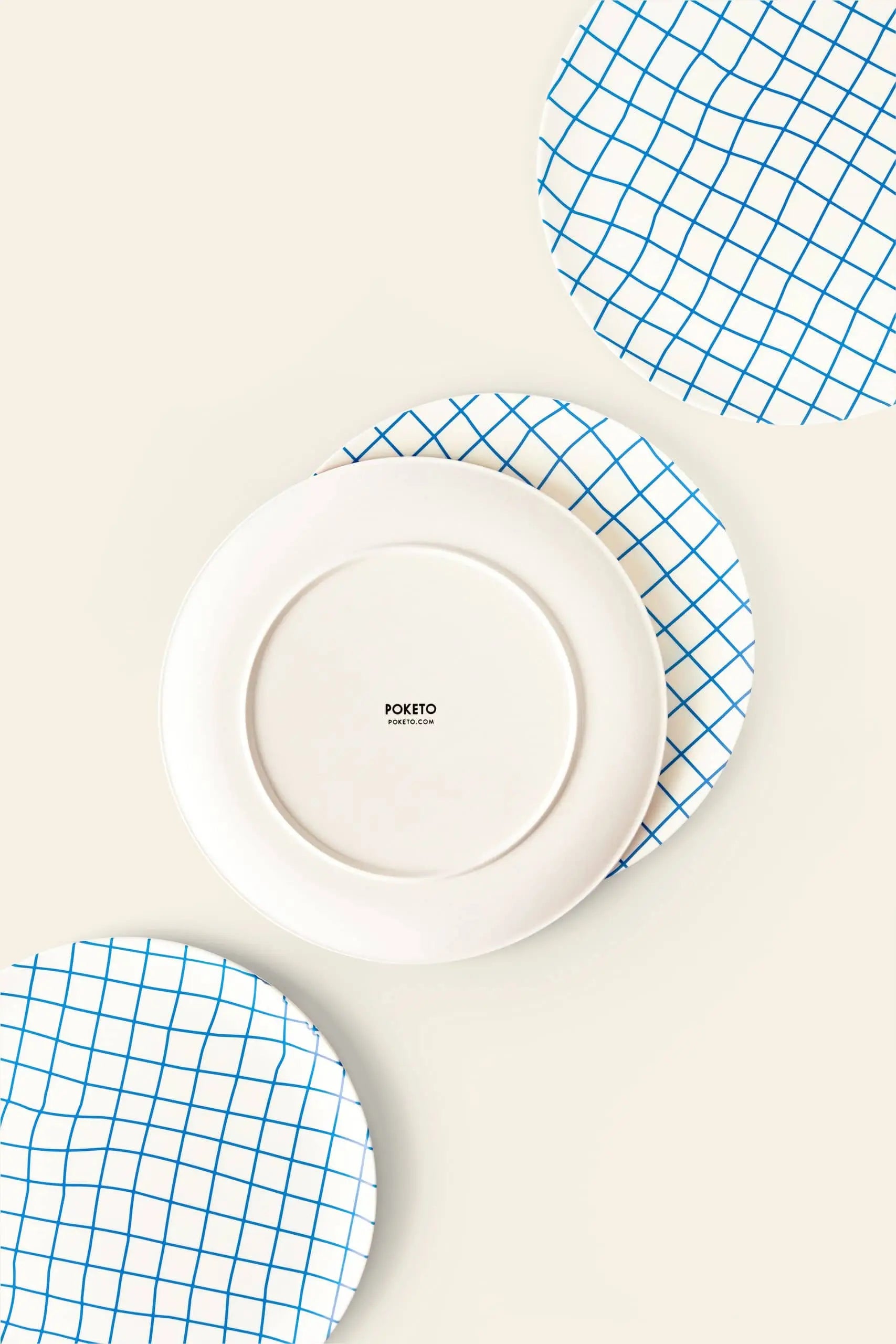 Three round plates on a light background: two with blue grid patterns and one plain white Poketo Bamboo Dinner Plate in the center, showing the Poketo brand—perfect for eco-friendly dinner parties.