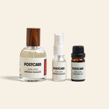 Three labeled Postcard bottles—including the luxe Hotel Lobby diffuser oil in a 10g bottle—promise a 5-star experience, with spray and dropper varieties from Postcard, all set against a plain light background.