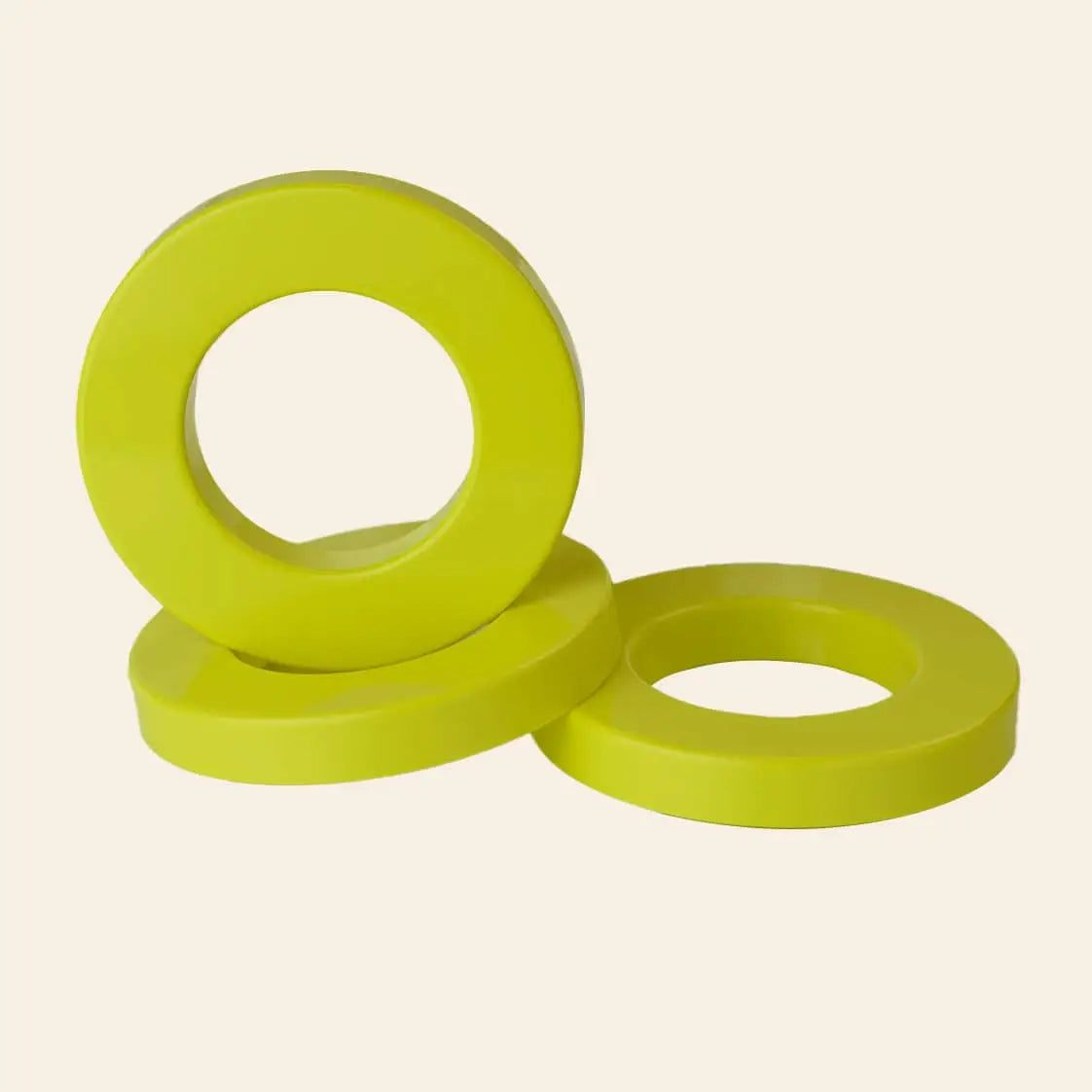 Three vibrant Ring A Date Calendar Rings from Ring-A-Date—yellow, flat, and circular with large center holes—are stacked on a light background. Ideal for customizing calendars or pairing with Ring-A-Date wall calendars.