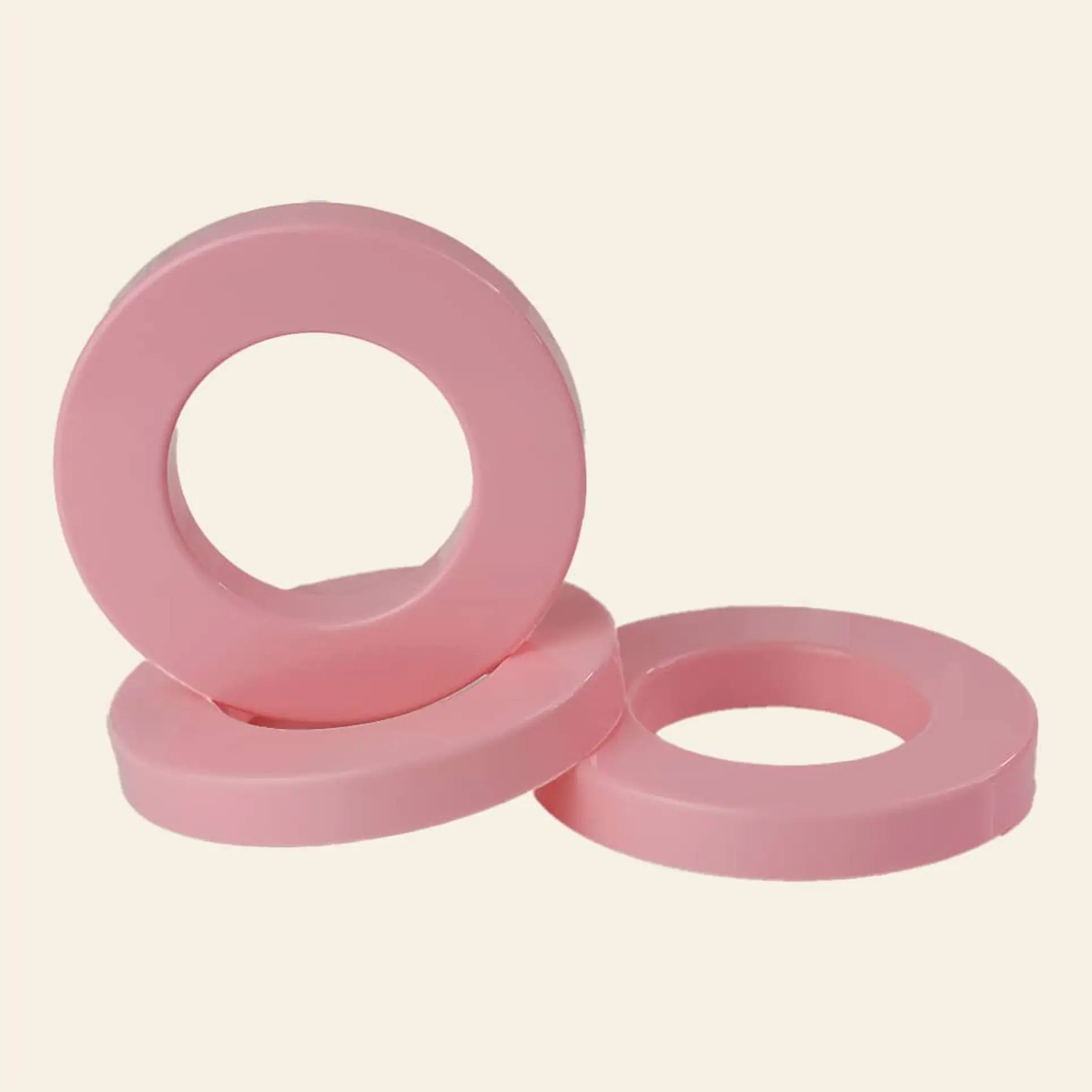 Three vibrant pink Ring A Date Calendar Rings by Ring-A-Date are stacked against each other on a plain, light background, evoking the playful style of classic Ring-A-Date wall calendars.