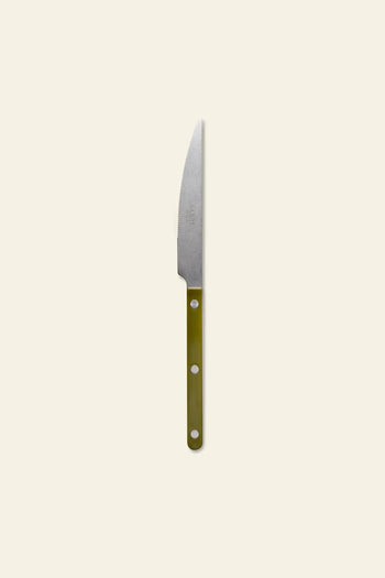 The Sabre Bistrot Vintage Dinner Knife by Sabre features a pointed stainless steel blade and a green handle with three silver rivets, inspired by French bistrot style and shown on a light beige background.