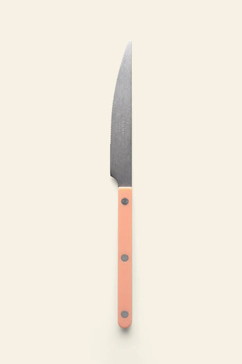 The Sabre Bistrot Vintage Dinner Knife by Sabre features a silver blade and light pink handle, displayed against a plain off-white background in classic French bistrot style.