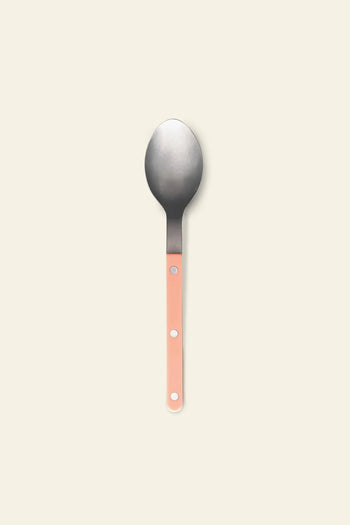 The Sabre Bistrot Vintage Soup Spoon by Sabre features a wide, round stainless steel bowl and a peach handle with two silver rivets, shown on an off-white background—ideal for adding French cafe charm to your table.