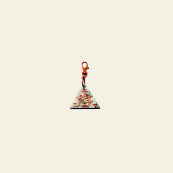 The School of Tomorrow Keychain - White by School of Tomorrow is a triangular HDPE plastic keychain with a red clasp, adorned with festive Christmas gifts, candy canes, and ornaments on a plain background for a greener future.