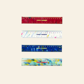 Four eco-friendly School of Tomorrow Math Instruments 20cm Thick Rulers—red, speckled white, blue, and speckled yellow HDPE plastic—each labeled SCHOOL-TOMORROW in yellow, are arranged horizontally on a light background.