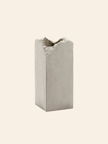 The Serax Broquaine Concrete Vase S - Grey by Serax is a rectangular vase with smooth sides and a rough, uneven top edge, highlighted against a plain beige background.