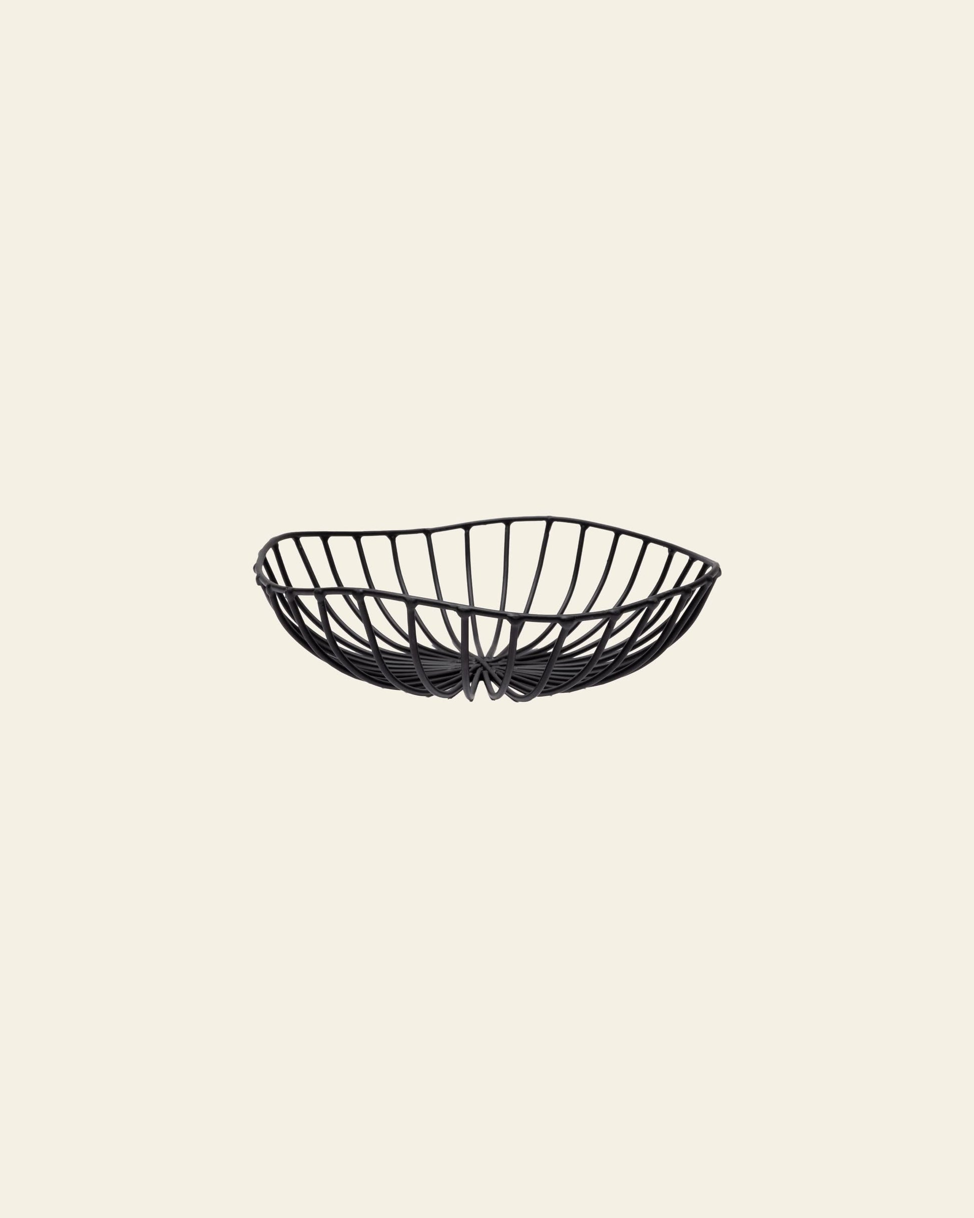 The Serax Catu Bread Basket L - Black, by Serax, is a shallow, oval metal basket with an open artistic design, displayed against a plain light beige background.