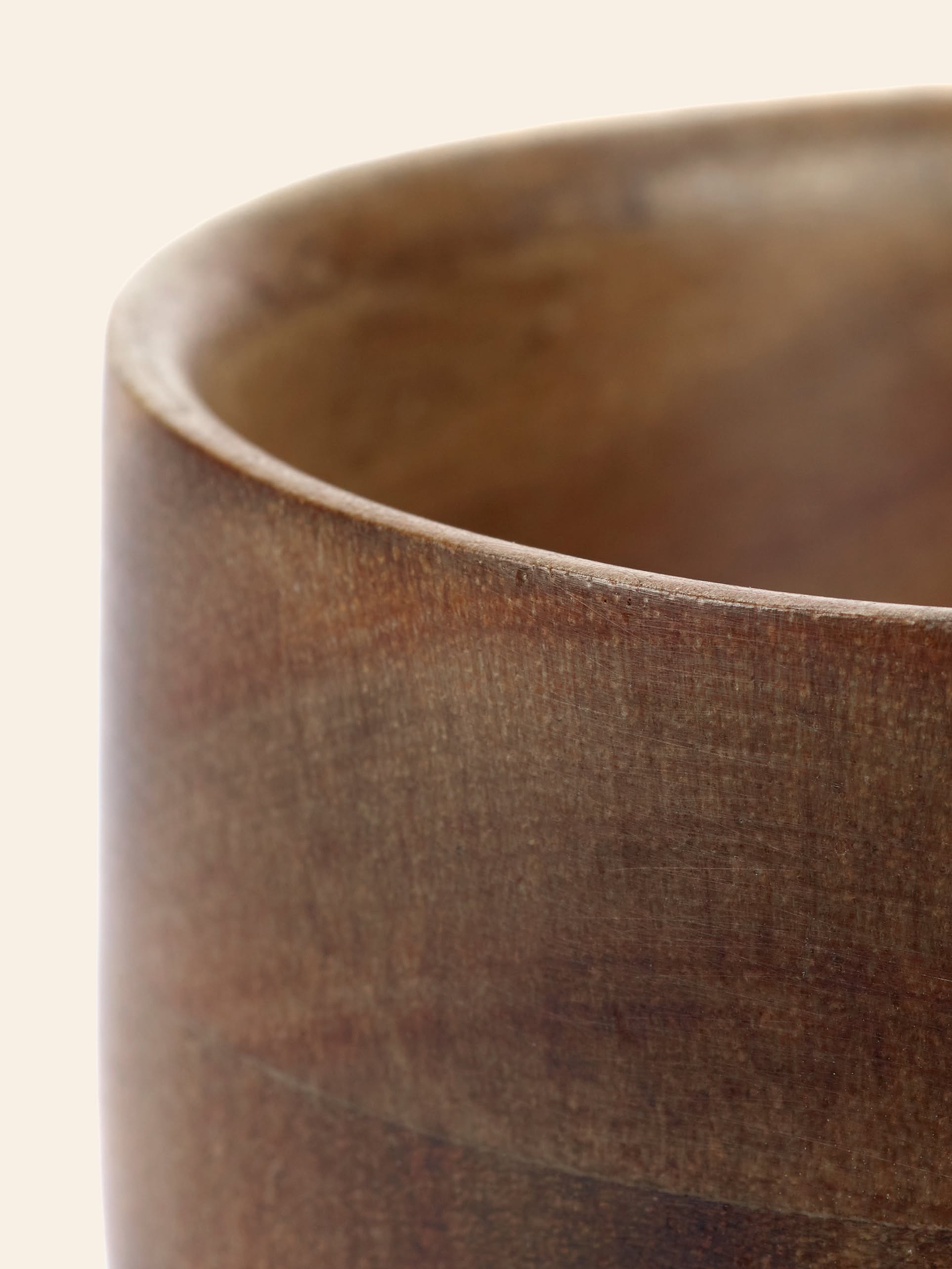 Close-up of the rim and upper side of the smooth, brown Serax Collage Tea Cup by Serax against a plain, light background.
