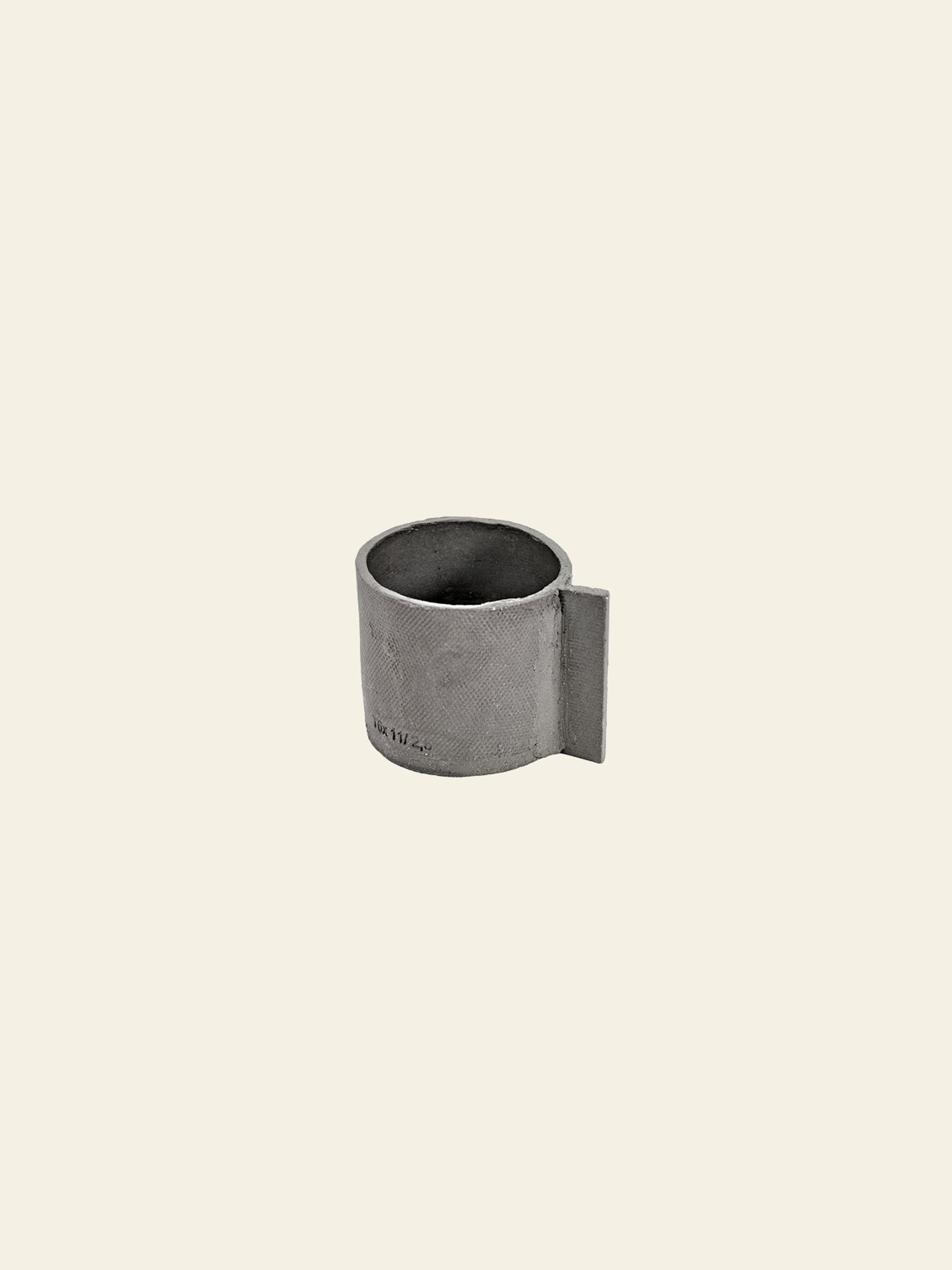 The Serax Fck Cup L in grey brown features a minimalist ceramic design with a flat, rectangular handle for a concrete look, showcased against a plain cream background.