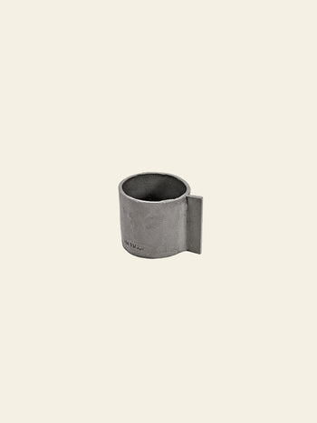 The Serax Fck Cup L in grey brown features a minimalist ceramic design with a flat, rectangular handle for a concrete look, showcased against a plain cream background.