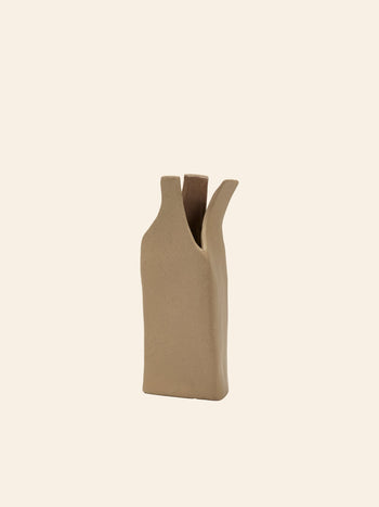 The Serax Flower Bottles Vase M in brown by Serax features an abstract ceramic design with an irregular rectangular base and two angled openings, ideal for minimalist decor, shown against a plain light background.