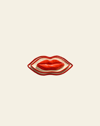 The Serax Les Objets Mouleversants Serving Dish S - Red, a ceramic plate shaped like red lips, is showcased on a plain light beige background—an eye-catching piece from Serax.
