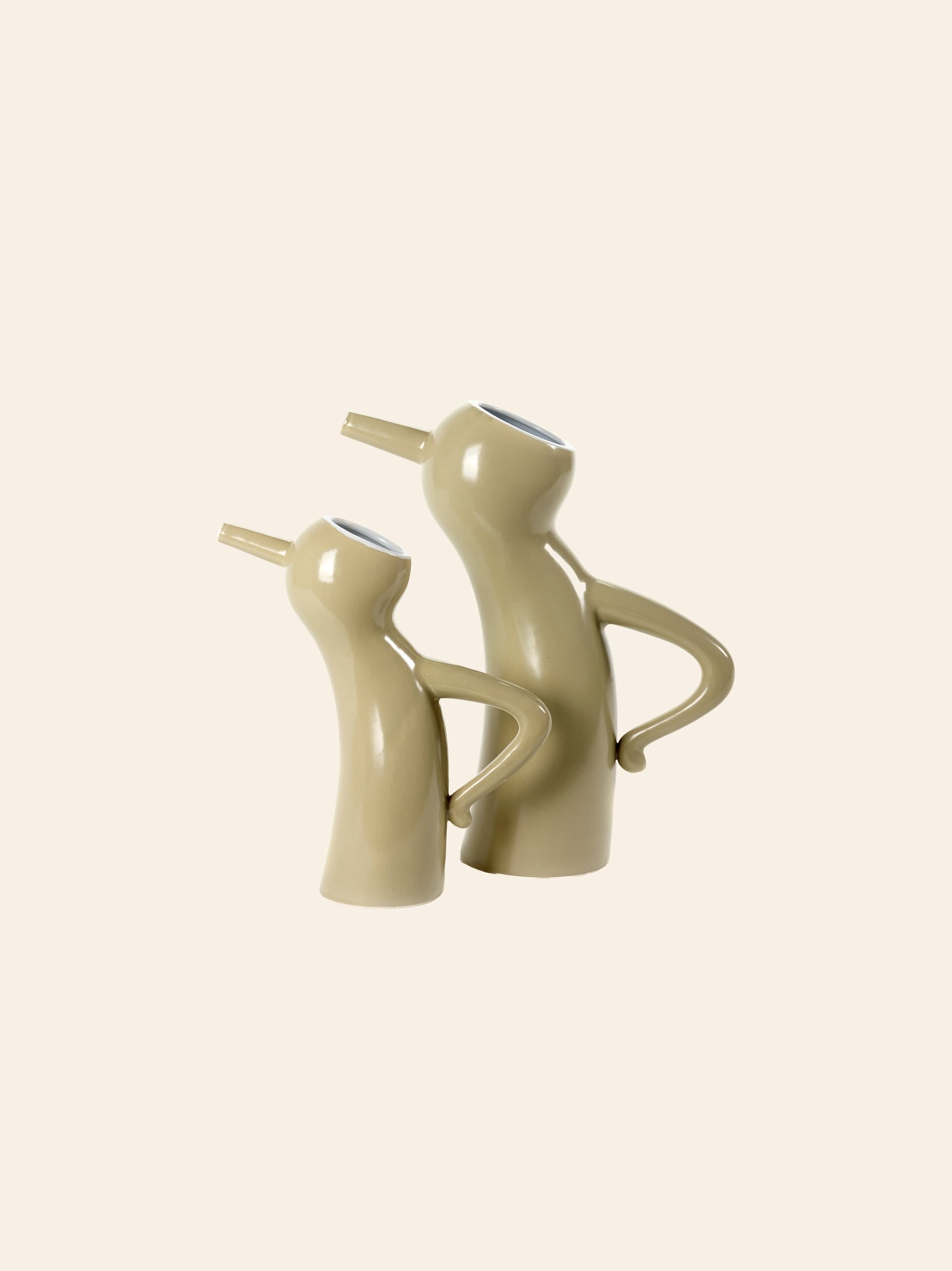 Two taupe ceramic Serax Monsieur Cruchot Jug L pitchers, featuring playful, abstract shapes with top spouts and side handles, stand as versatile decor accents against a plain light background.