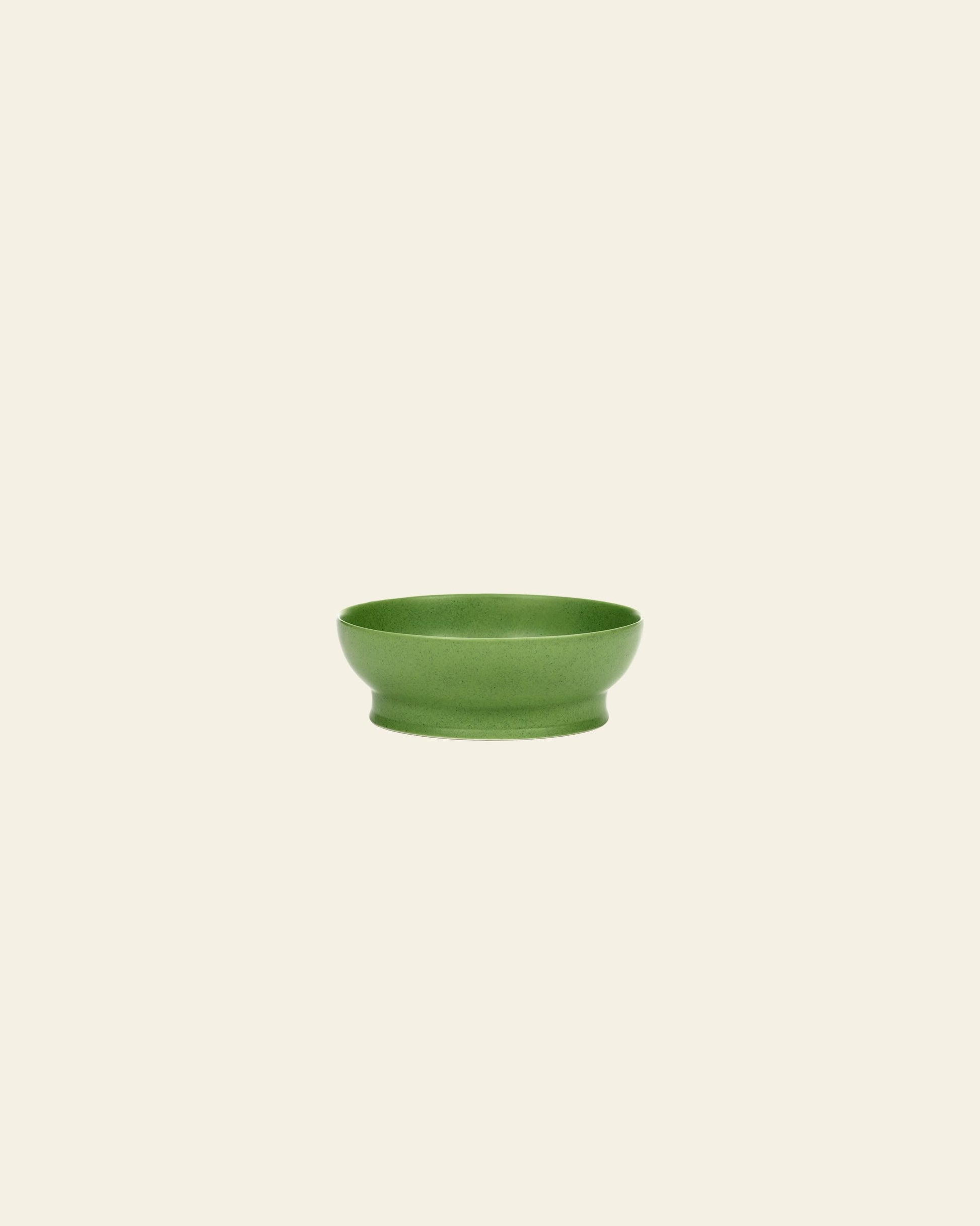 The Serax Ra Bowl S - Green by Serax is a small, round green porcelain bowl with a slightly flared base, shown against an off-white background—an elegant tableware piece for any setting.