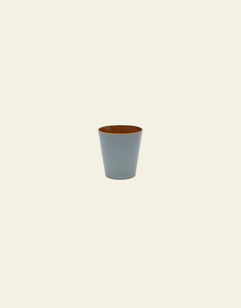 The Serax Terres De Rêves Conical Cup M features a handcrafted light blue glaze outside and brown inside, set against a plain light beige background.