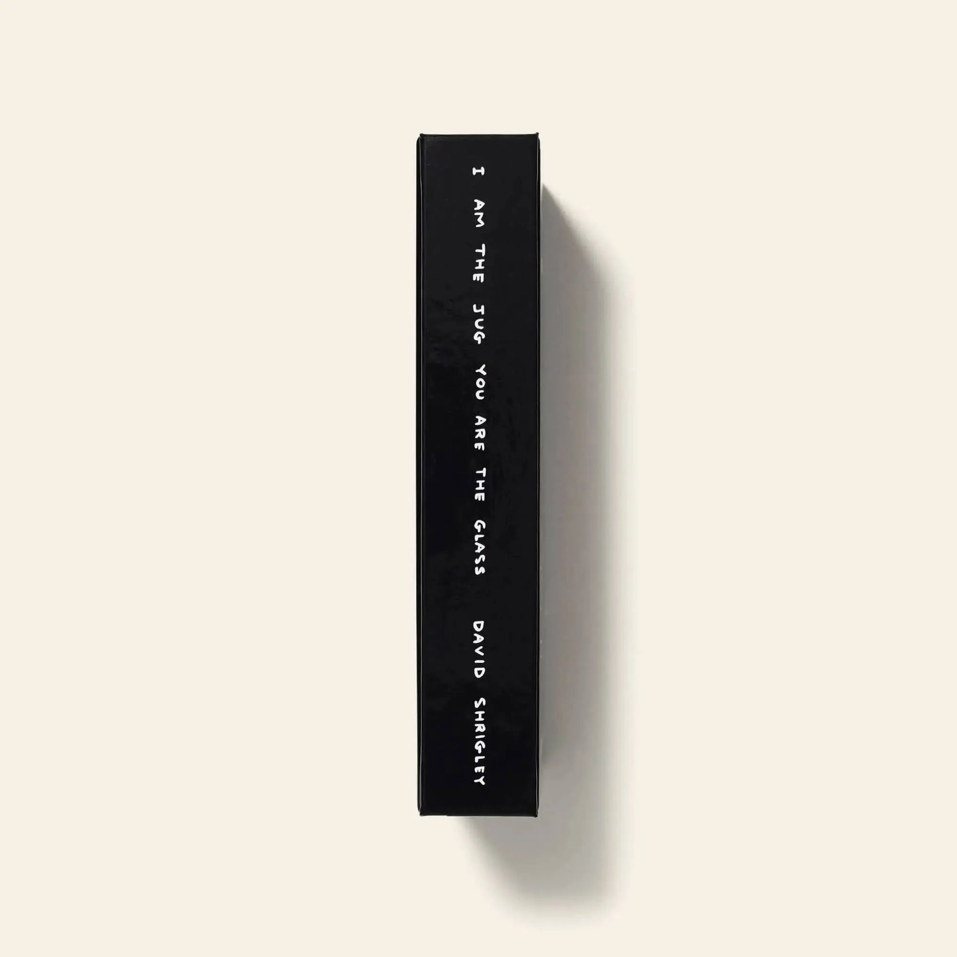 Shrig Shops limited edition David Shrigley - I Am The Jug You Are The Glass book features a black spine with white text and is set against a plain light beige background.