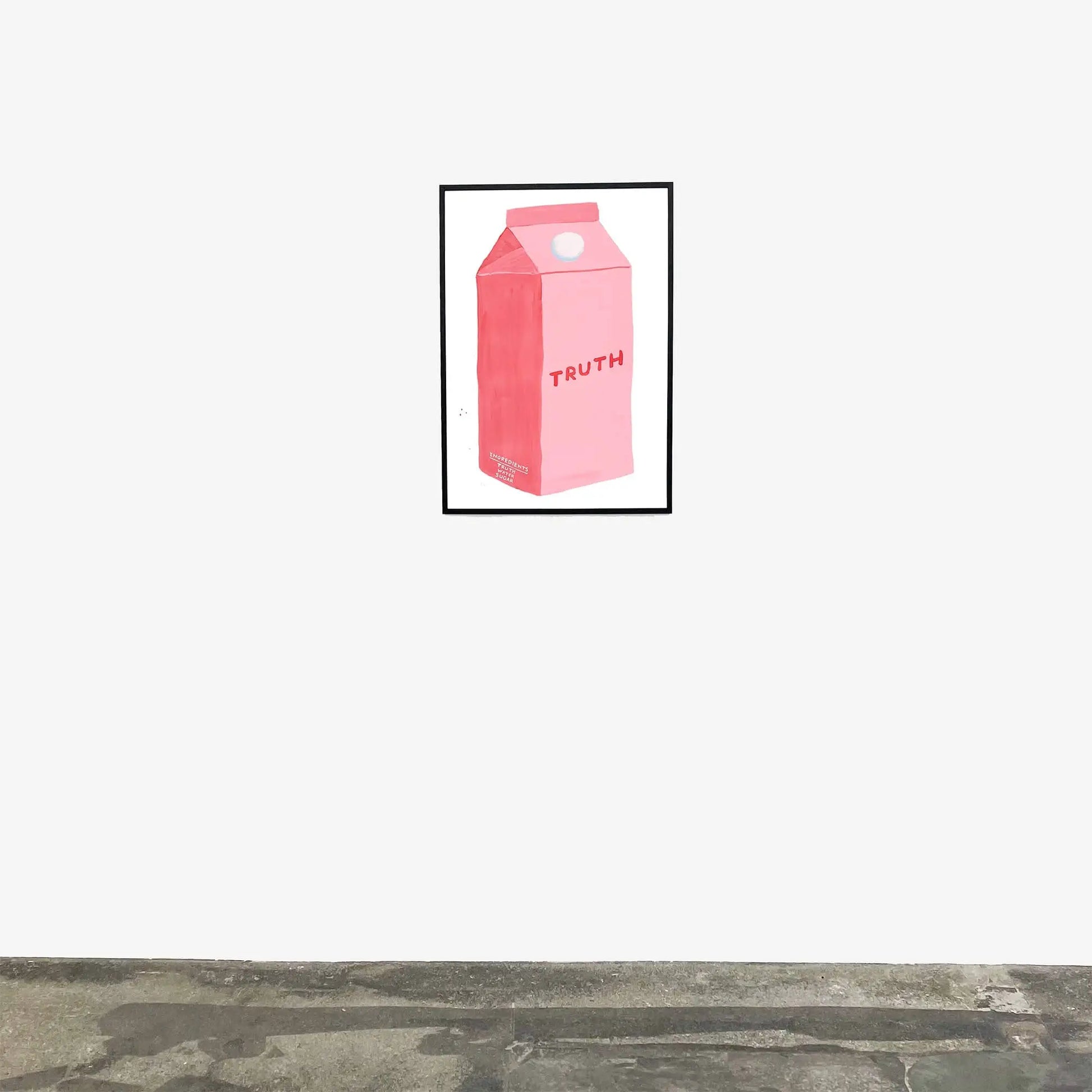 The Shrig Shop David Shrigley - Truth (60x80) framed artwork features a pink milk carton labeled TRUTH, hanging on a white wall above a gray concrete floor, reflecting the playful wit of Shrig Shop’s unique art.