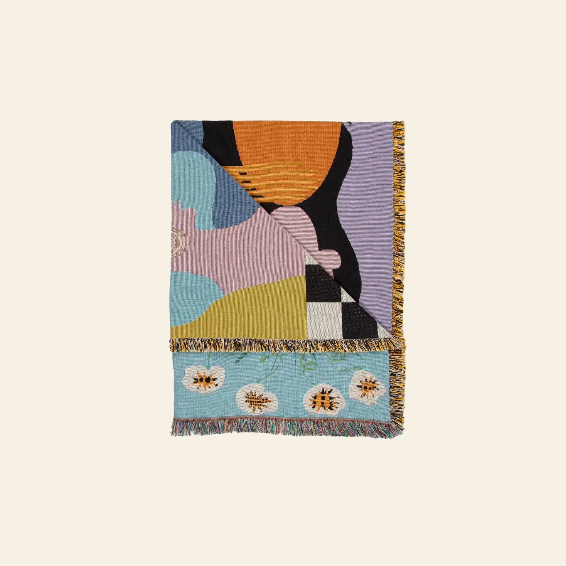 The Slowdown Studio Moretti Throw by Slowdown Studio is an eco-friendly woven blanket made from recycled cotton, featuring abstract shapes, a floral-patterned border, multicolored fringe edges, and a modern artistic design.