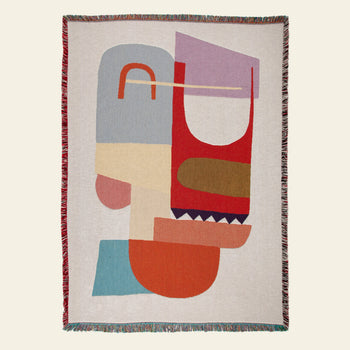 The Slowdown Studio Oroza Throw is a woven blanket with an abstract geometric design and multicolored fringe, made from eco-friendly recycled cotton for a stylish and sustainable touch.