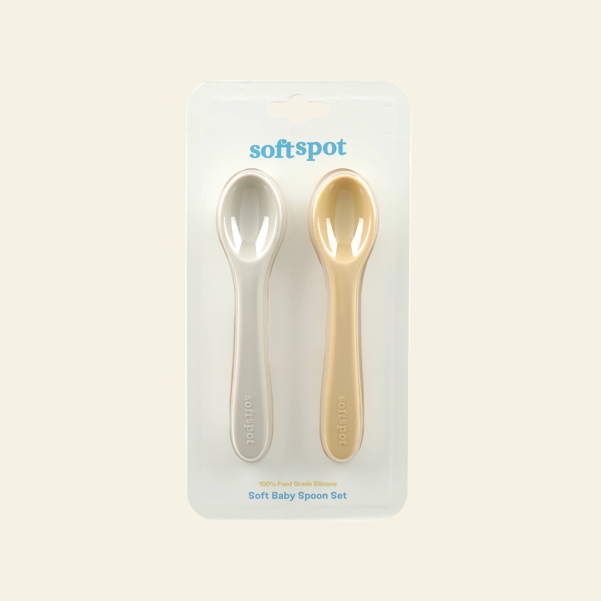 The Soft Spot Soft Baby Spoons, Set of 2, includes one light gray and one pale yellow silicone spoon on minimal white packaging. Designed for teething gums, these spoons make feeding easy and gentle for babies.