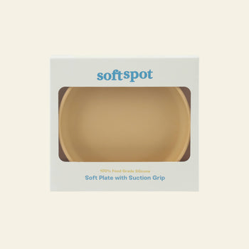A beige Soft Spot Soft Suction Plate, made from 100% food-grade silicone with a strong suction grip, comes in white packaging with a clear window. softspot appears at the top, highlighting its silicone and suction features below.