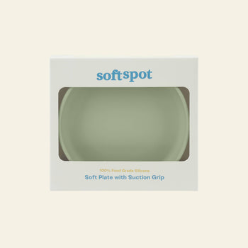 A pale green Soft Spot Soft Suction Plate made of food-grade silicone is visible through a window on the white Soft Spot box, labeled with the product name and featuring a strong suction grip for secure use.