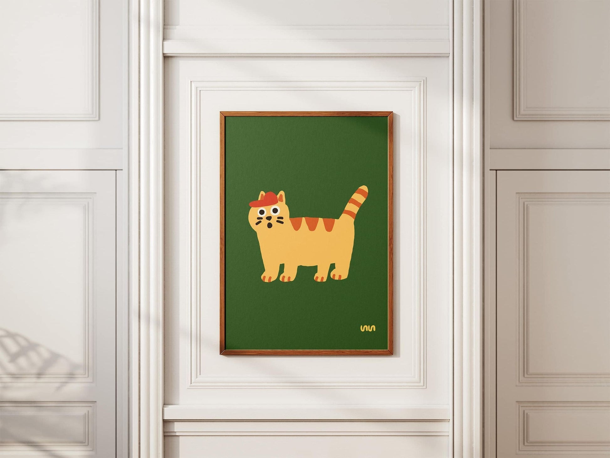 The Stacked Store Exclusive Scaredy Cat Poster (30x40) features an orange striped cartoon cat on a green background, adding playful charm to a white paneled wall.
