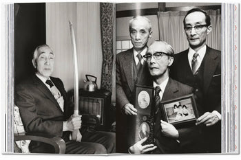 Four elderly men in suits pose in a traditional Japanese room; one holds a katana, others display family photos. This evocative scene, rich with heritage, recalls classic Japanese photography featured in TASCHEN Araki by TASCHEN.