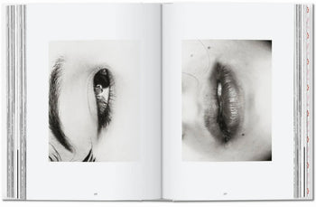 The open TESCHEN Araki book reveals two black-and-white close-ups: the left page shows an eye, while the right displays lips and part of a face—both images in Araki’s signature detailed style.