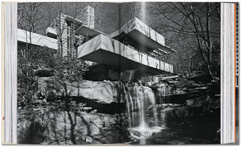Open book displays a black-and-white photo of Frank Lloyd Wright’s iconic house above a waterfall, surrounded by trees—an architectural masterpiece highlighted in the TASCHEN Frank Lloyd Wright edition by TASCHEN.